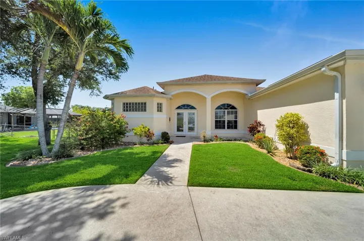 Mediterranean / spanish house featuring french doors, stucco siding, and a front yard