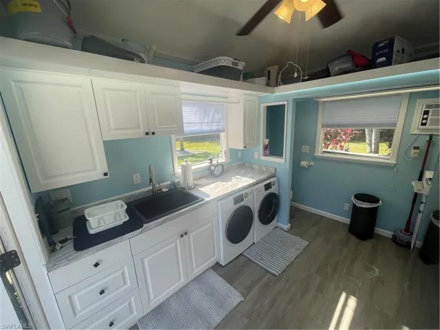 Laundry room with washer and dryer, dark wood-style floors, and a ceiling fan
