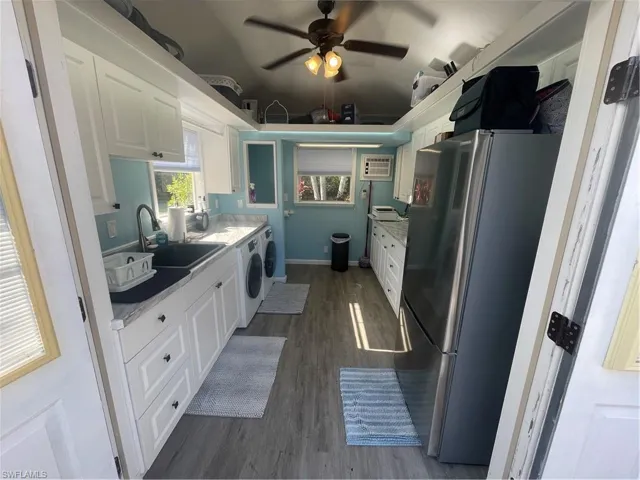 Kitchen featuring white cabinetry, refrigerator, and dark wood-style flooring