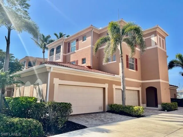 View of front of home with driveway, stucco siding, a tile roof, and a garage