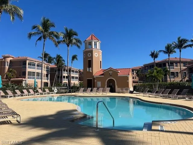 Community pool featuring fence and a patio area