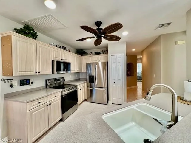 Kitchen with visible vents, ceiling fan, a sink, and stainless steel appliances