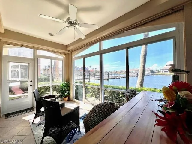 Sunroom with a water view and tile patterned floors