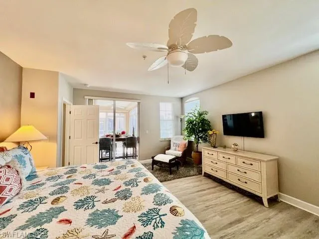 Bedroom with a ceiling fan, baseboards, light wood-style floors, and access to exterior