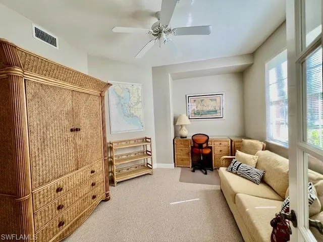 Living area featuring baseboards, carpet floors, ceiling fan, and visible vents