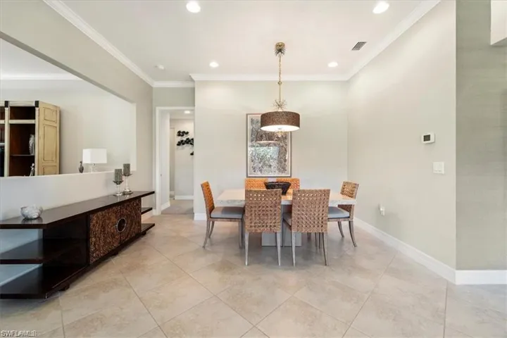 Dining space with ornamental molding, recessed lighting, and light tile patterned floors