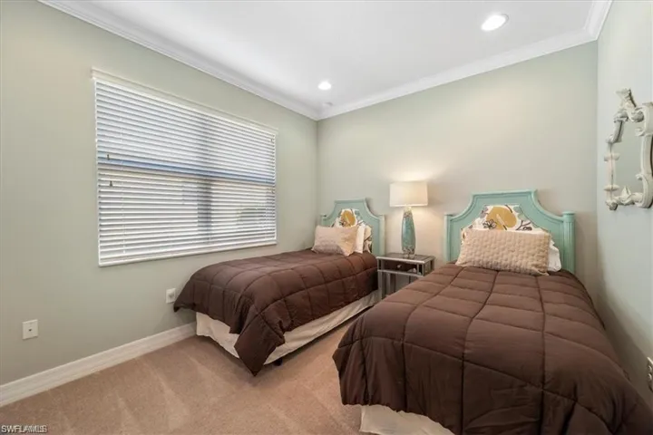 Carpeted bedroom with ornamental molding and recessed lighting