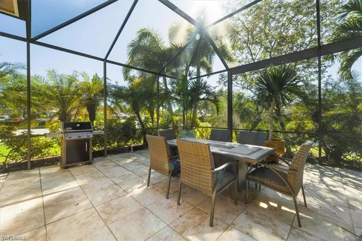 View of patio with outdoor dining area, a sunroom, and a lanai