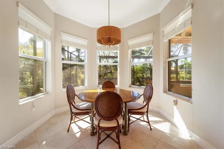 Sunroom / solarium with crown molding, healthy amount of natural light, and tile patterned flooring