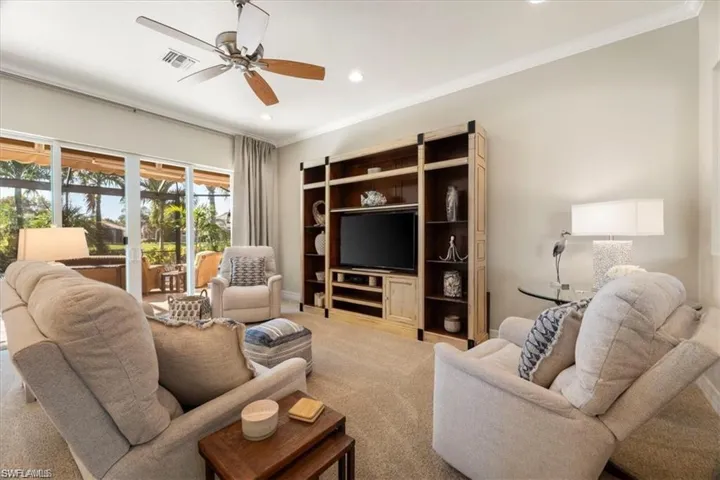 Carpeted living area featuring ornamental molding, ceiling fan, and recessed lighting