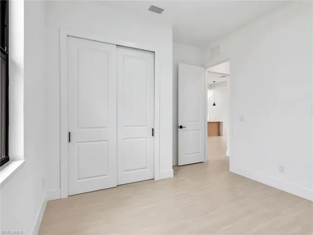 Unfurnished bedroom featuring light wood-style flooring and a closet