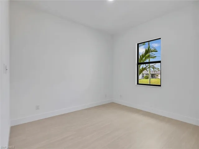 Empty room featuring baseboards and light wood-style flooring