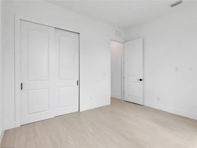 Unfurnished bedroom with a closet and light wood finished floors