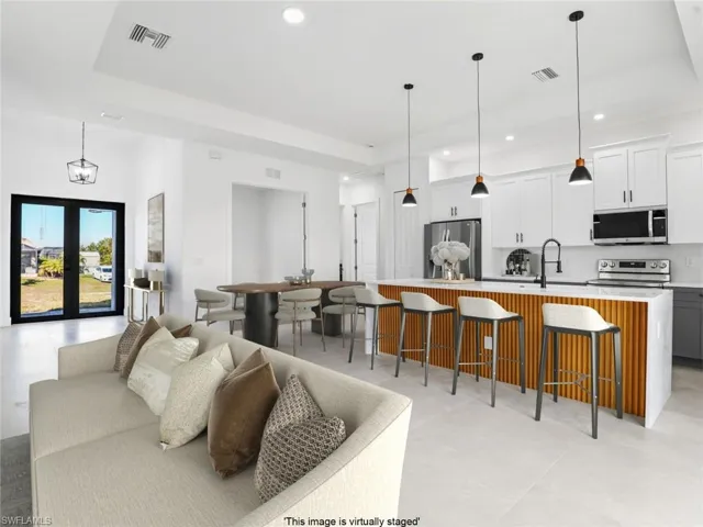 Living area with recessed lighting, french doors, and a raised ceiling