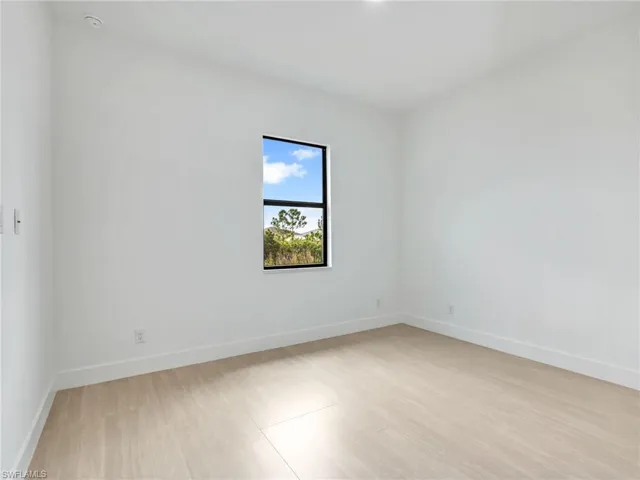 Unfurnished room with baseboards and light wood finished floors