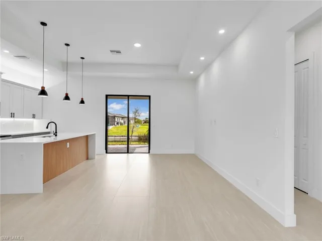 Unfurnished living room featuring recessed lighting and baseboards