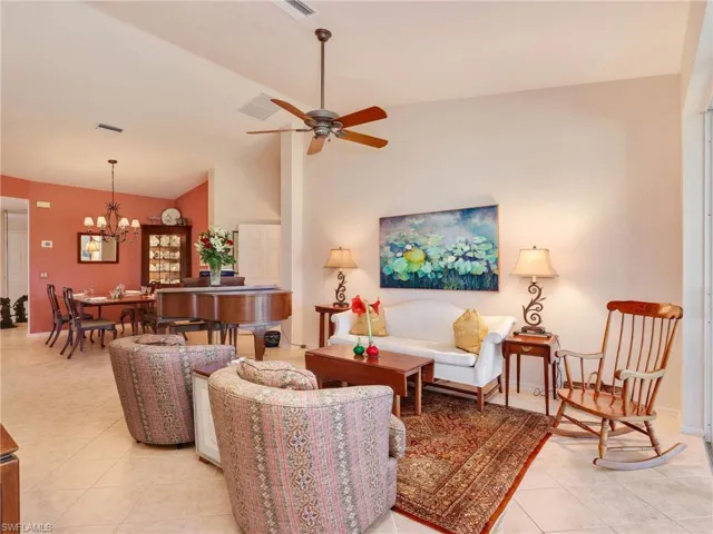 Living area featuring lofted ceiling, a ceiling fan, and light tile patterned flooring