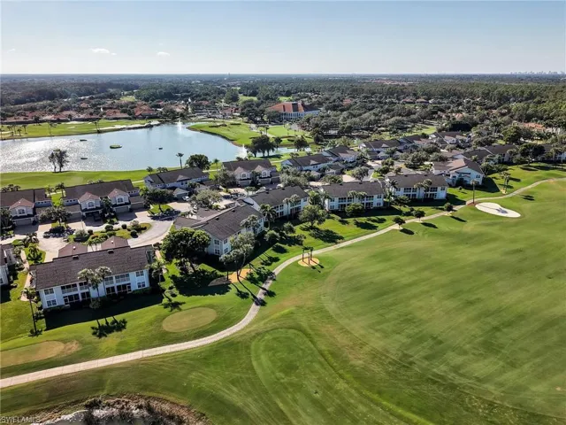 Aerial perspective of suburban area featuring a golf course and a large body of water