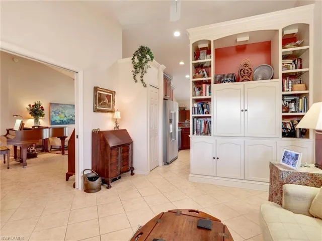 Sunroom with golf course view, tile patterned flooring, and healthy amount of natural light, sunset views, accesses to kitchen, living, and primary suite