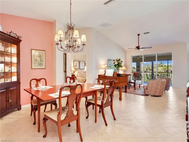 Dining area with a chandelier, vaulted ceiling, and light tile patterned floors