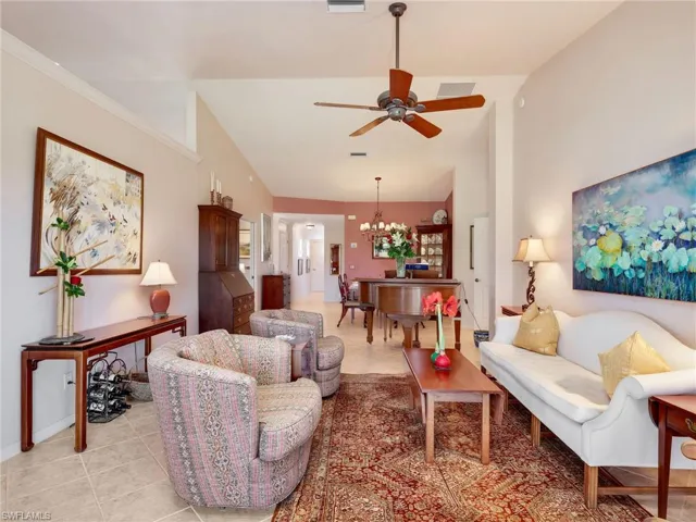 Living area with ceiling fan, open to lanai, and tile patterned floors