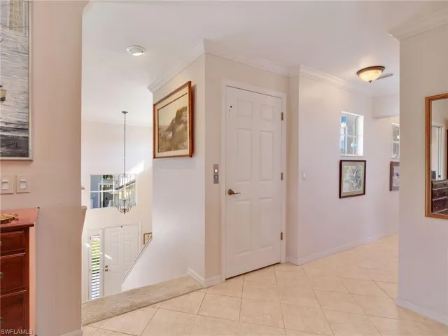 Elevator, Hallway with ornamental molding, elevator, and tile patterned flooring