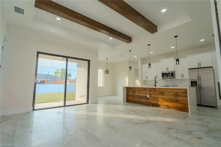 Kitchen featuring pendant lighting, white cabinets, wood ceiling, stainless steel appliances, and backsplash