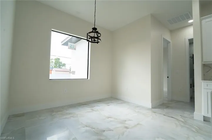 Unfurnished dining area featuring a notable chandelier