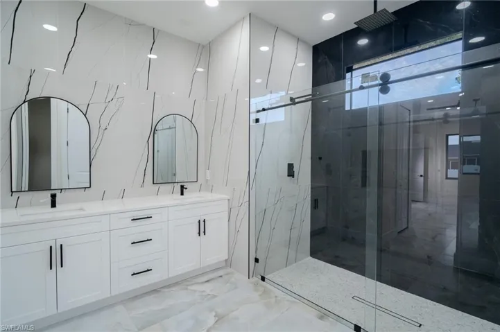 Bathroom featuring a shower with door and vanity