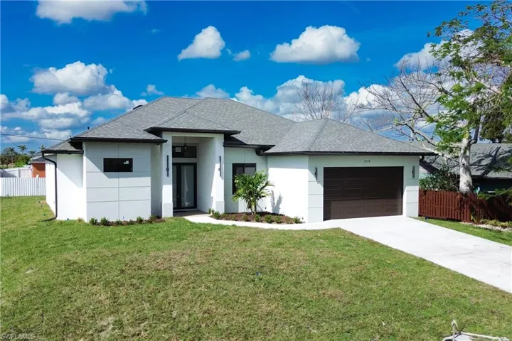 View of front of house with a garage and a front lawn