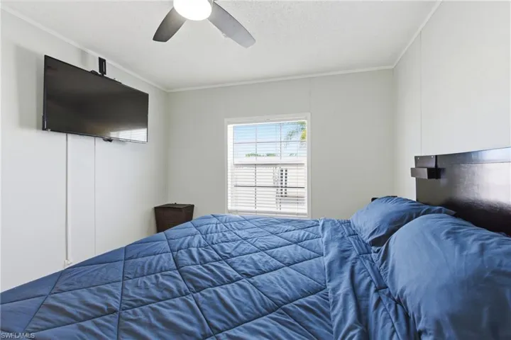Room featuring a window with horizontal blinds, a ceiling fan, and light-toned walls