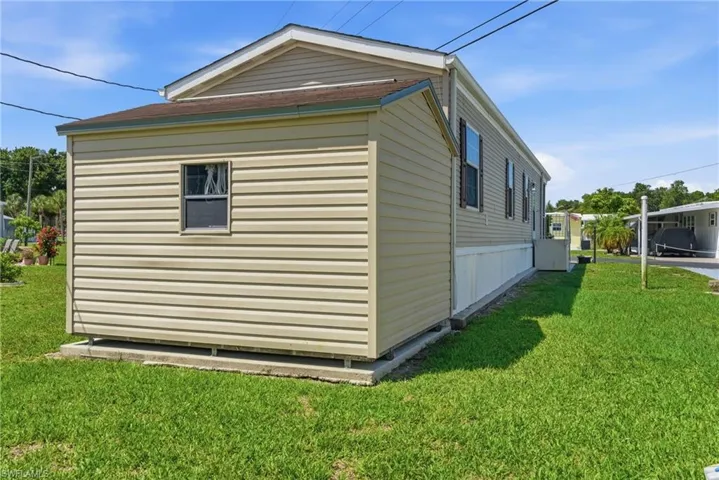 Back of home with storage shed, featuring vinyl siding, a gabled roofline