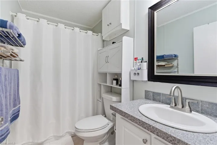 Bathroom featuring a vanity with an integrated sink, speckled countertop, and tiled backsplash