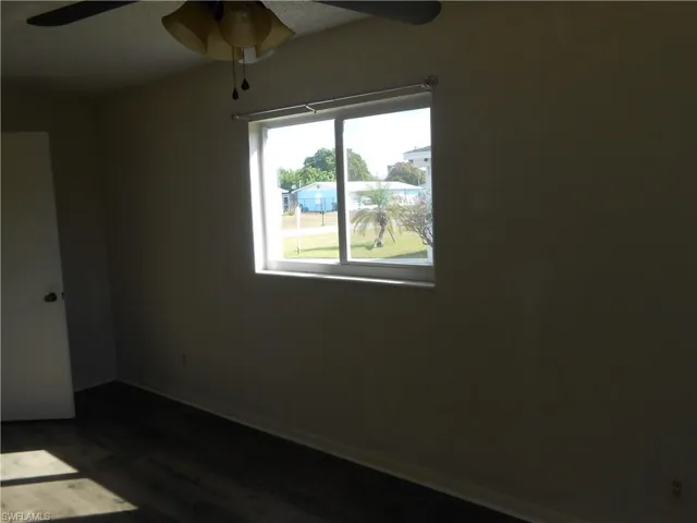 Spare room featuring ceiling fan and dark wood finished floors