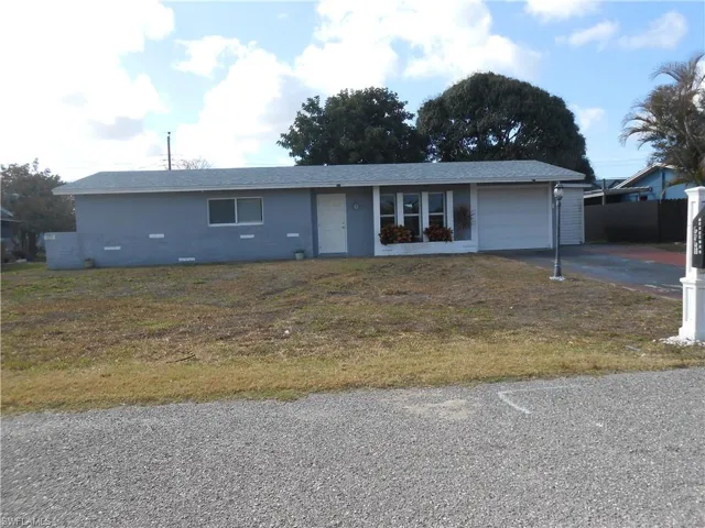 Ranch-style home with an attached garage, driveway, and a front lawn