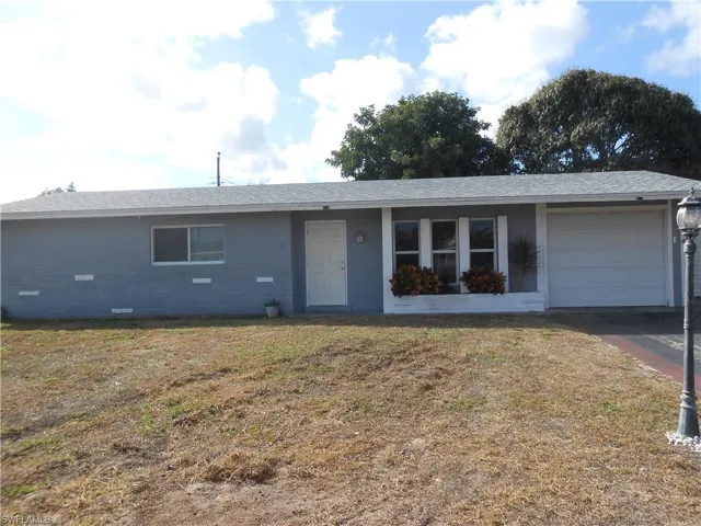 Ranch-style home with a front lawn, an attached garage, crawl space, a shingled roof, and driveway