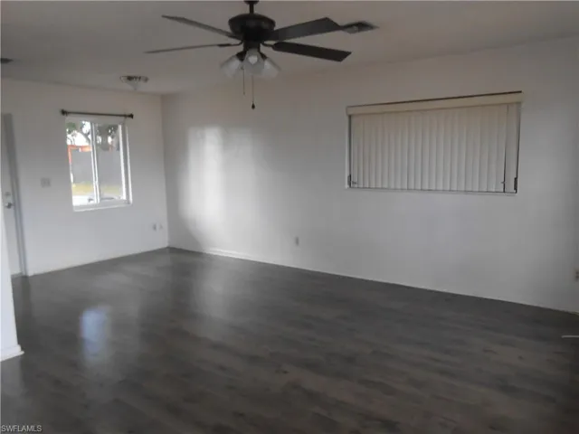 Unfurnished room featuring ceiling fan and dark wood finished floors