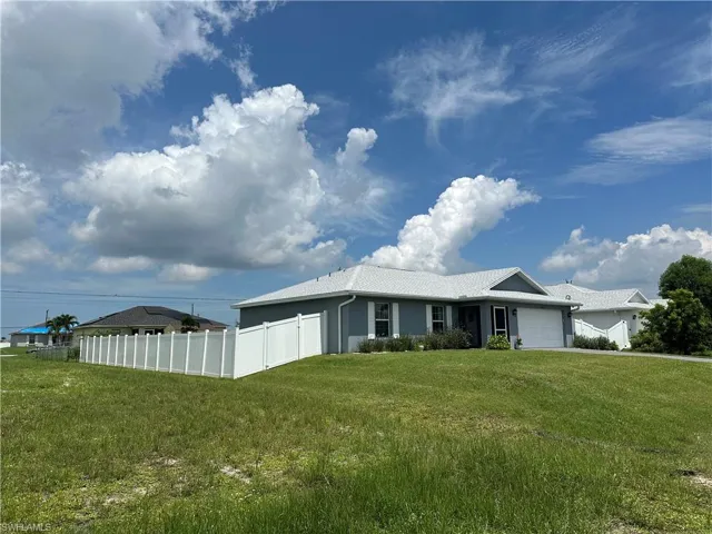 View of property exterior featuring 2 car garage and raised yard