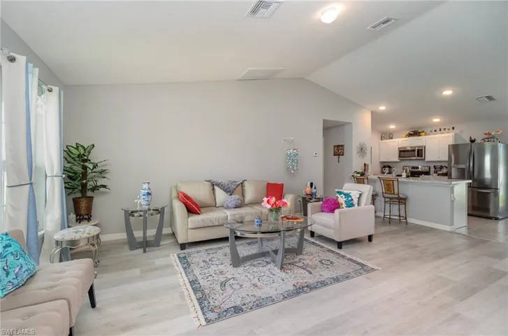 Living room with vaulted ceiling with kitchen view. Great flow.