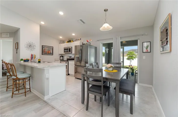 Kitchen Dining area with sliders opening to cozy screened-in lanai.