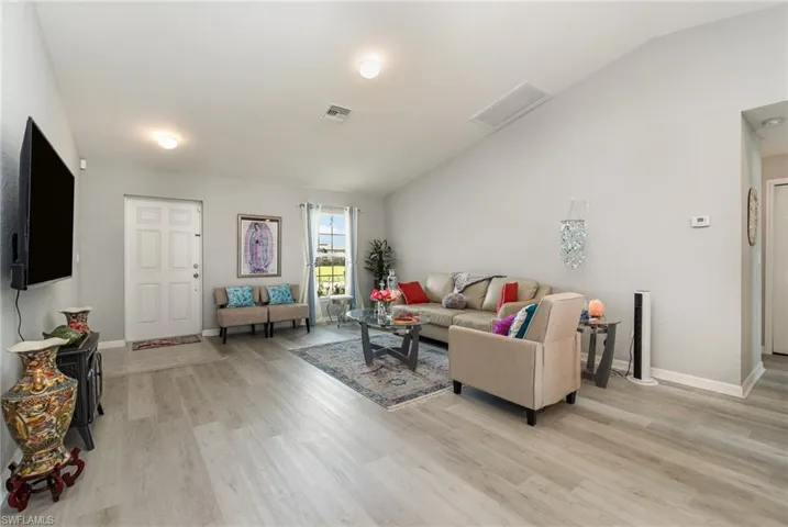 Welcome Home! Living room featuring vaulted ceiling and luxury vinyl plank flooring