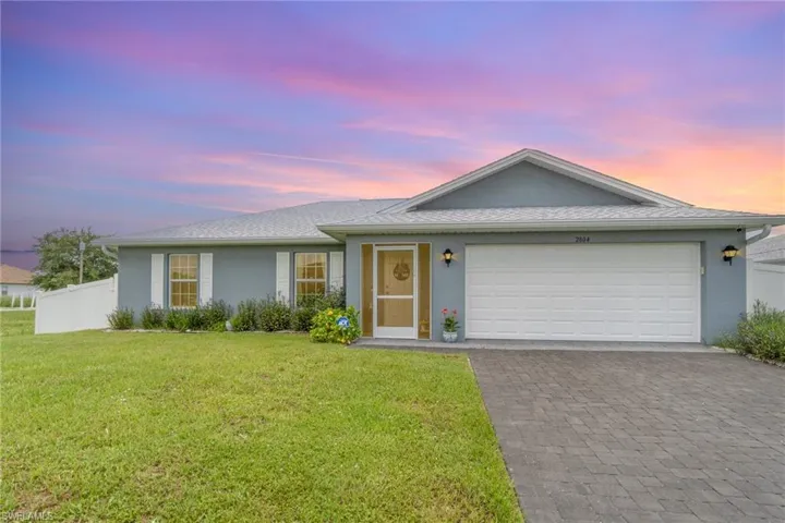Ranch-style house with 2 car garage and a raised front lawn.