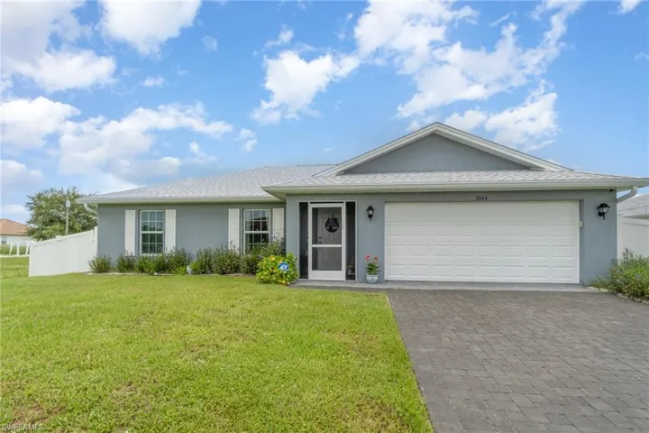 Single story home featuring 2 car garage and elevated front lawn