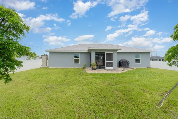 Rear view of house with a yard