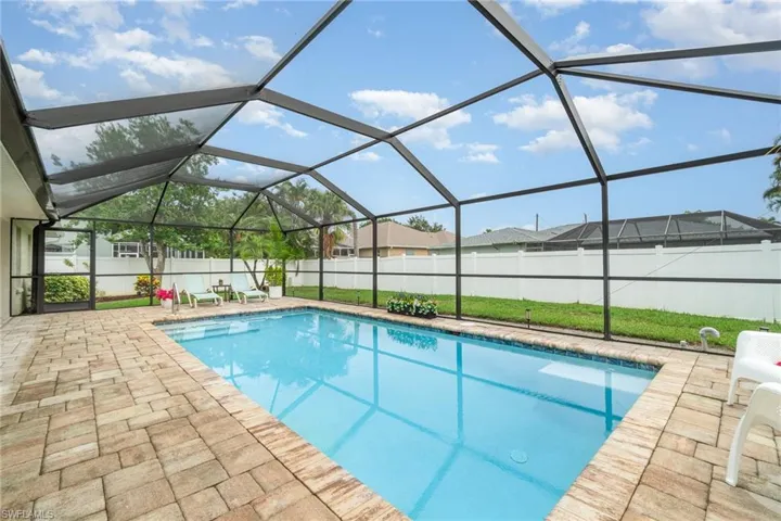 View of swimming pool with a patio, a fenced backyard, and screened enclosure