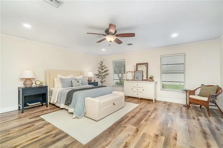 Primary Bedroom featuring ornamental molding, light wood-style floors, baseboards, a ceiling fan, and recessed lighting