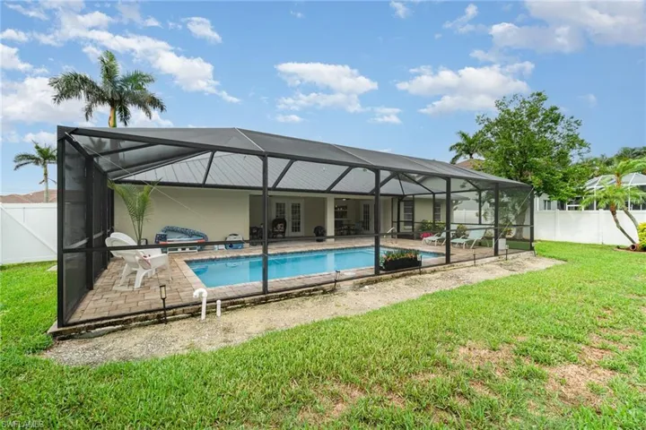 Rear view of house featuring a patio area, a lanai, screened pool area, and french doors