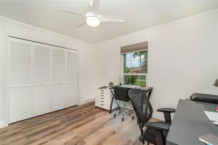 3rd bedroom (used as office) with ornamental molding, light LVP  wood-style finished floors, baseboards, and ceiling fan