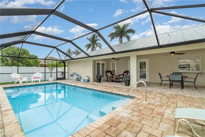 View of swimming pool featuring a patio area, screen enclosure, and outdoor dining space