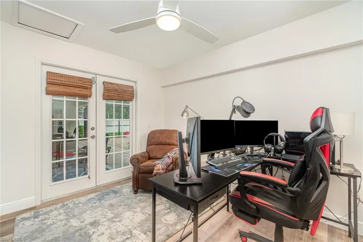 3rd bedroom , used as an Office, featuring LVP wood-style finished floors, french doors to lanai, and ceiling fan